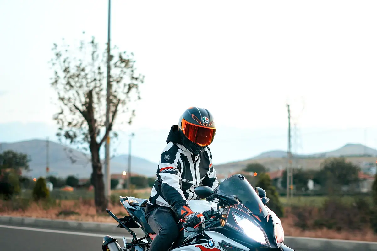 A rider in a full-face helmet and leathers on a sport motorcycle.